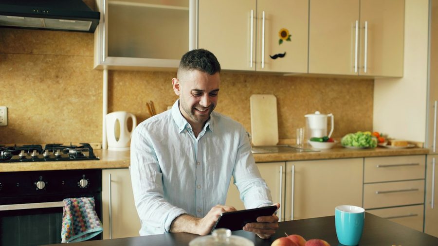 Man smiling at his kitchen table at home